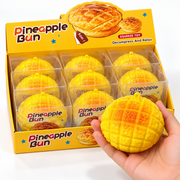 Pineapple bun squishy toy with yellow retail display of individually boxed squeeze toys