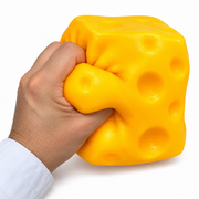 Adult hand squeezing the large yellow cheese-block toy to demonstrate its soft flexible shape