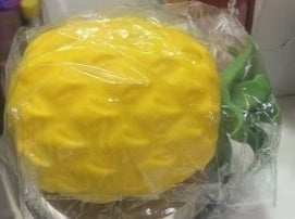 Original supplier photo: Yellow pineapple squishy with a textured oval body and green leaf crown