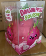 Original supplier photo: Pink dragon fruit squishy with green scales in clear retail packaging