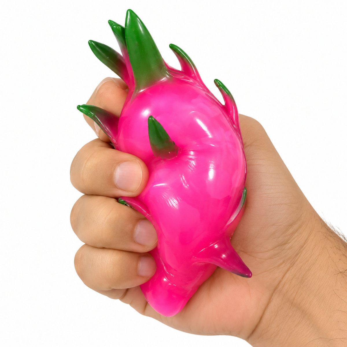 Hand squeezing a glossy pink dragon fruit squishy toy with green leaf details